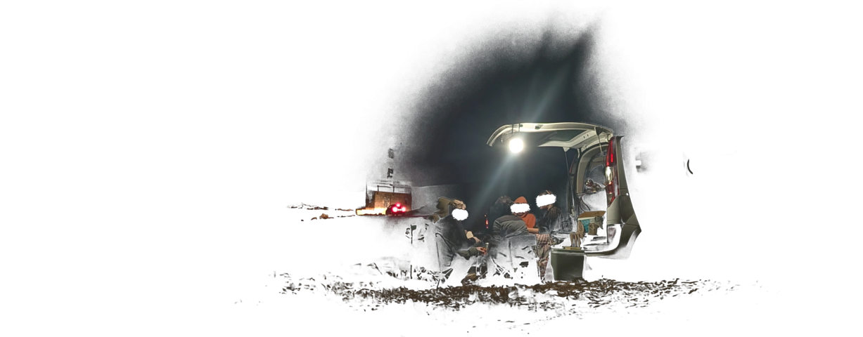 Des gens sous une lumière de camping attachée au coffre d'une voiture